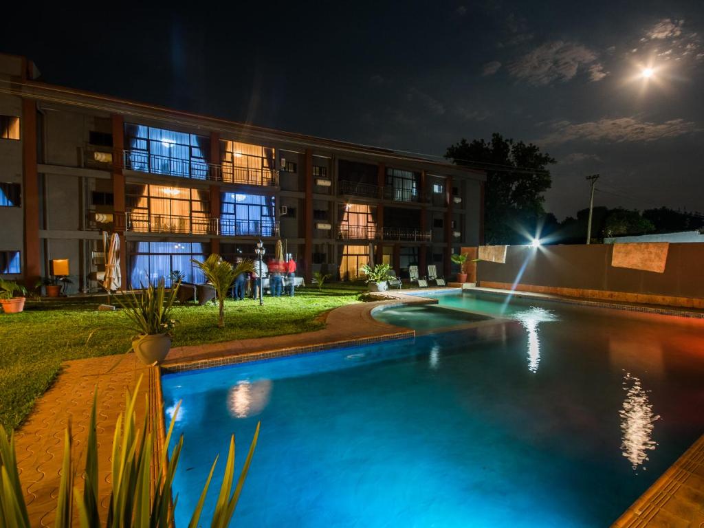 Kitwe的住宿－舍伯恩酒店，一座游泳池,在晚上在建筑物前