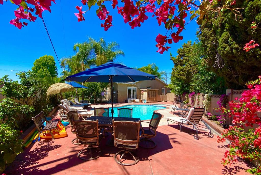 a patio with chairs and an umbrella and a pool at Disneyland Paradise 6 BedRoom 4 Bathroom Pool Spa Games in Anaheim