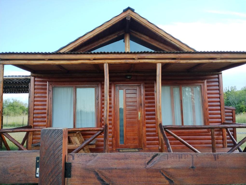 een blokhut met ramen aan de voorzijde bij Cabañas MoonRose in Concepción del Uruguay