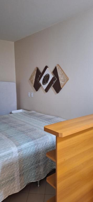 a bedroom with a bed and a wooden table at Eldorado Flat Service apto 601- BL 1 in Caldas Novas