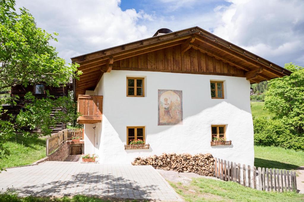 a white house with a wooden roof at Chalet Hafling Leckplått in Avelengo