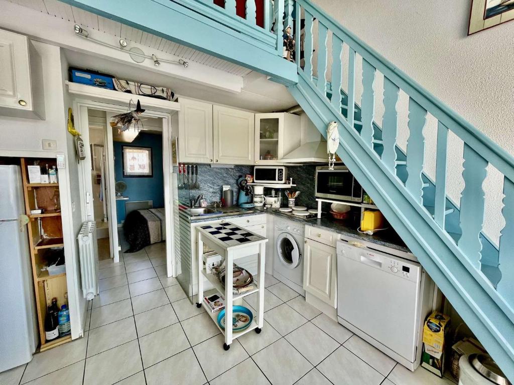 une cuisine avec un escalier et un lave-linge. dans l'établissement Appartement 2 Pièces avec Parking à Saint-Cyprien, Vue Marina - FR-1-225D-220, à Saint-Cyprien