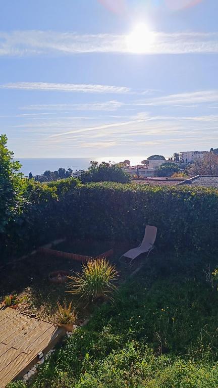 une chaise assise dans l'herbe dans une cour dans l'établissement Super deux pièces vue mer, à Nice