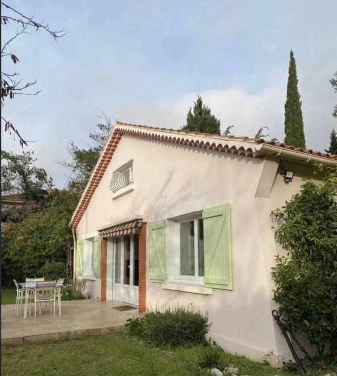 Cette maison blanche dispose d'une terrasse et d'une table. dans l'établissement Maison familiale les Sablettes près de la mer, à La Seyne-sur-Mer