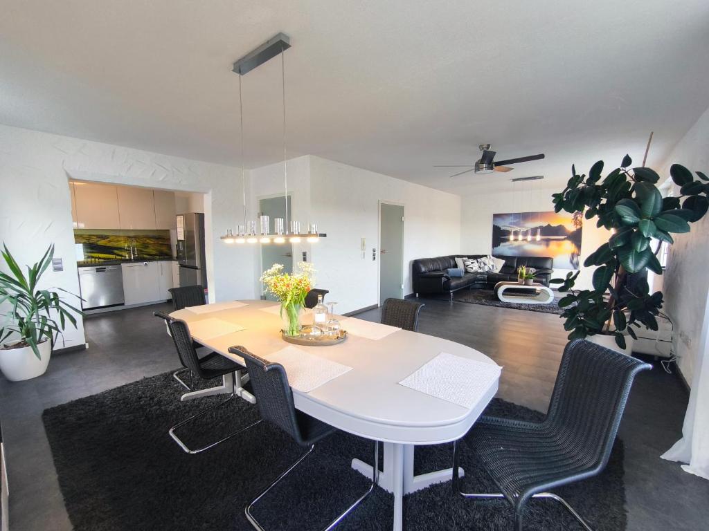 a dining room and living room with a white table and chairs at Ferienhaus Goldgrube - 5 Zimmer - 140qm am Fluss in Katzweiler