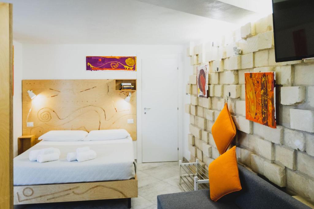 a hotel room with two beds and a tv at Le Cave di Fontane Bianche in Cassibile