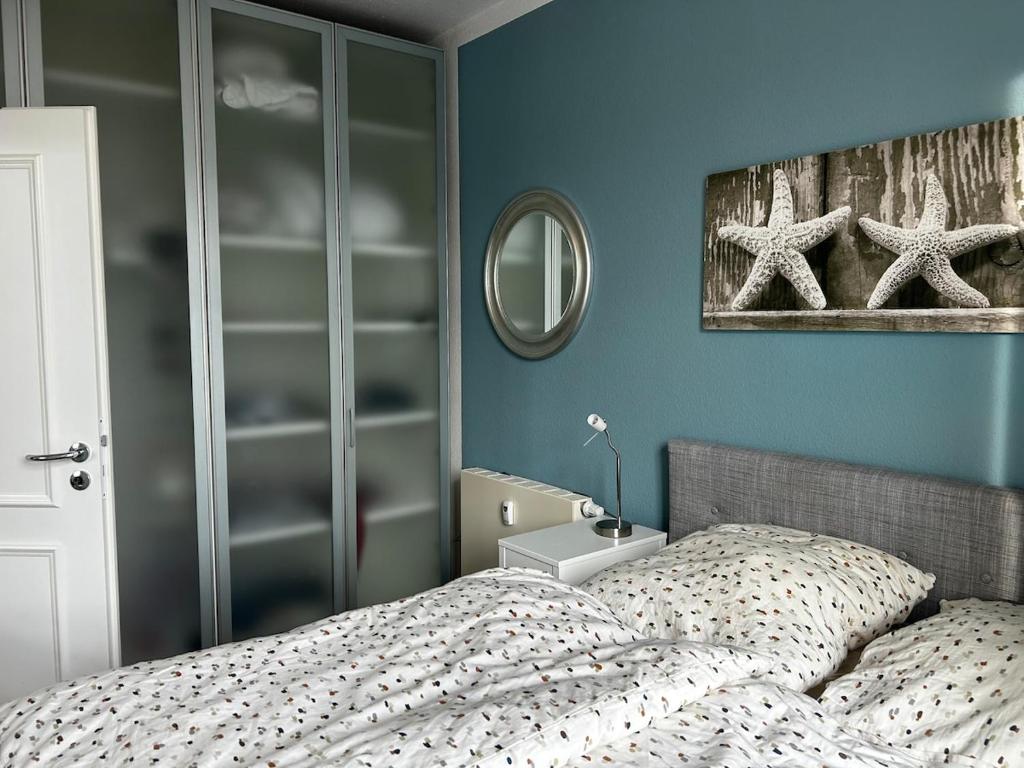 a bedroom with a bed and a mirror at Villa Heimkehr Apartment 6 in Göhren