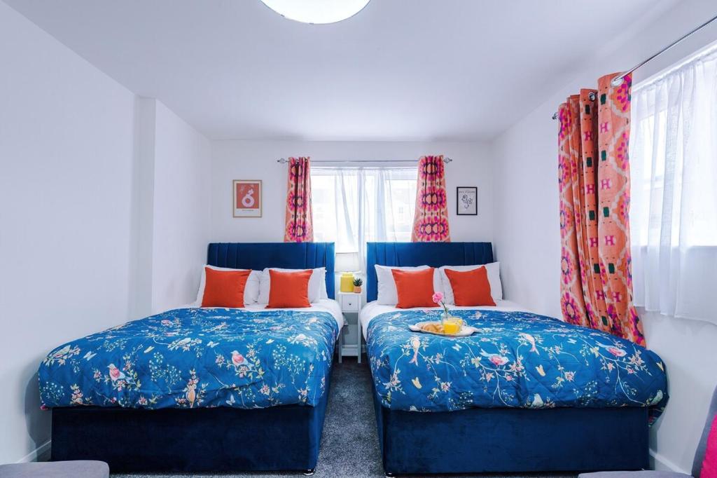 two beds in a room with blue and orange pillows at Jephsons Lodge Studio 3 - Free Netflix, Parking, WiFi in Leamington Spa