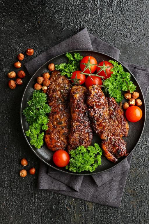 un piatto di alimenti con carne e verdure su un tavolo di Patan Square - 2 km from Patan Durbar Square a Patan