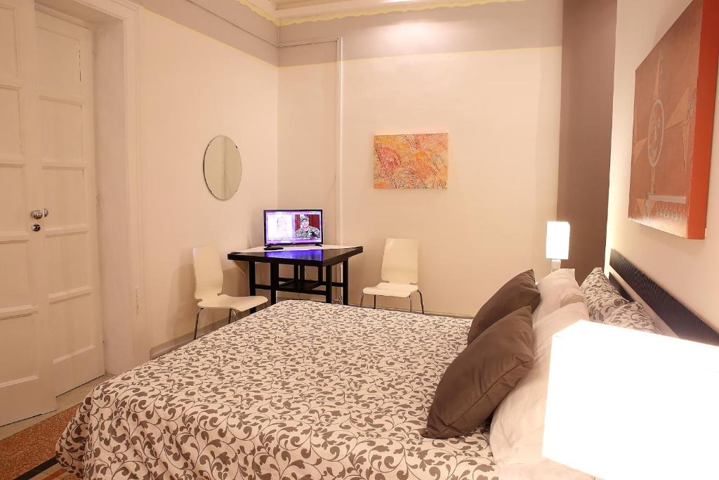 a bedroom with a bed and a desk with a laptop at Room and Suite - BARI CENTRALE - in Bari