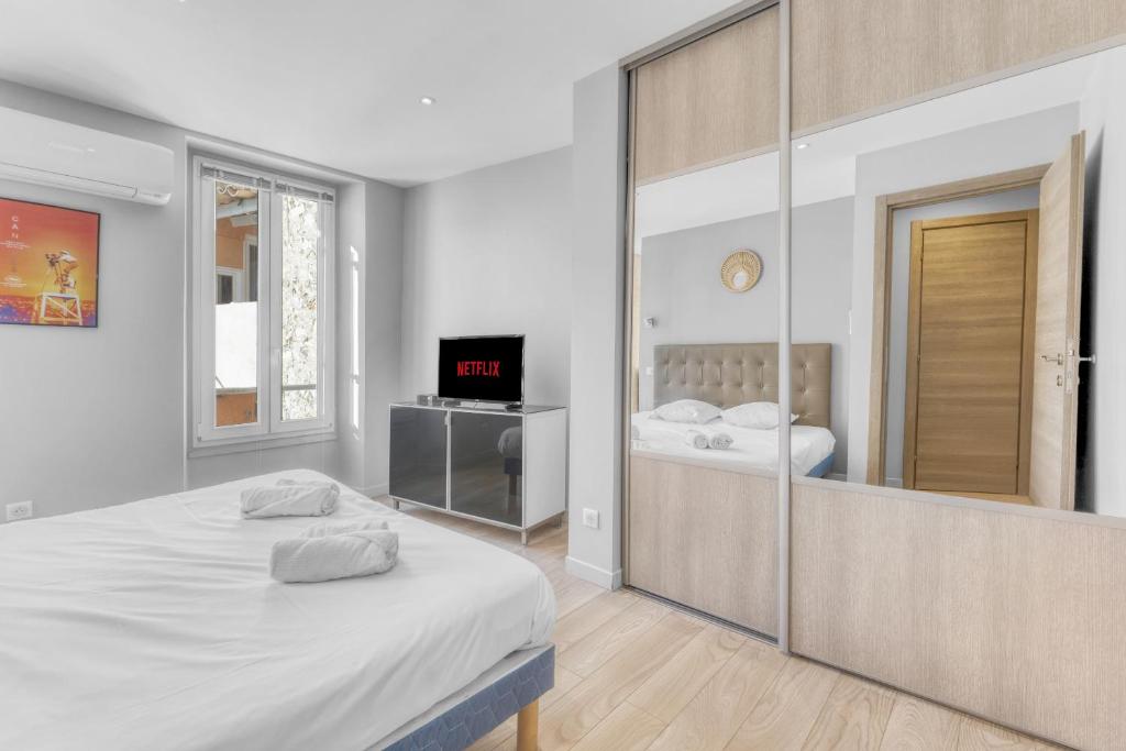 une chambre avec un lit et un grand miroir dans l'établissement F3 Riouffe , Hypercentre à 2minutes du Palais des Festivals, à Cannes