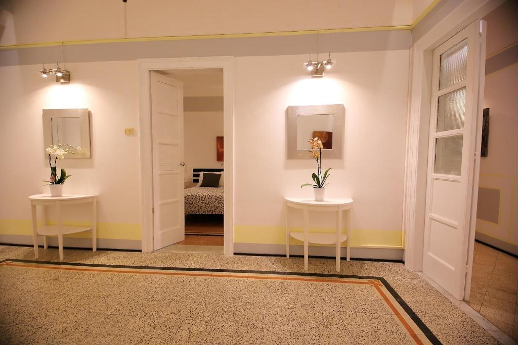 a hallway with two tables and two mirrors at Room and Suite - BARI CENTRALE - in Bari