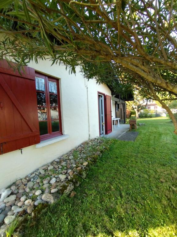 une maison avec une cour herbeuse à côté d'un bâtiment dans l'établissement Soulac sur mer - Maison individuelle avec jardin, à Soulac-sur-Mer