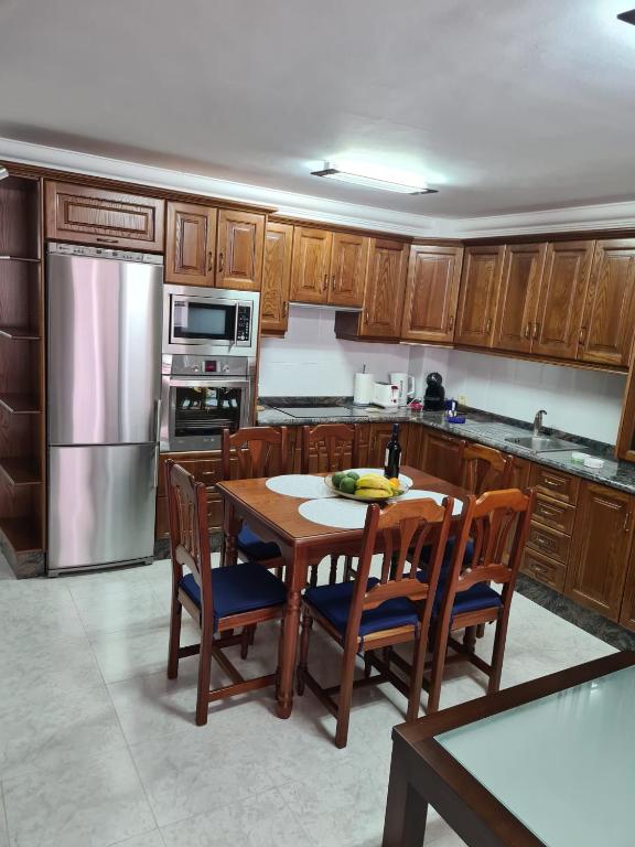 a kitchen with a table and chairs and a refrigerator at Casa Ulla in Puerto Naos