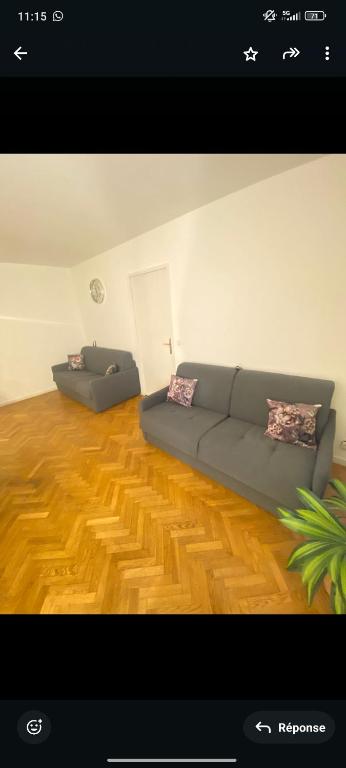 - un salon avec un canapé et du parquet dans l'établissement Spacieux 2 pièces avec place de parking , la Villette, à Aubervilliers