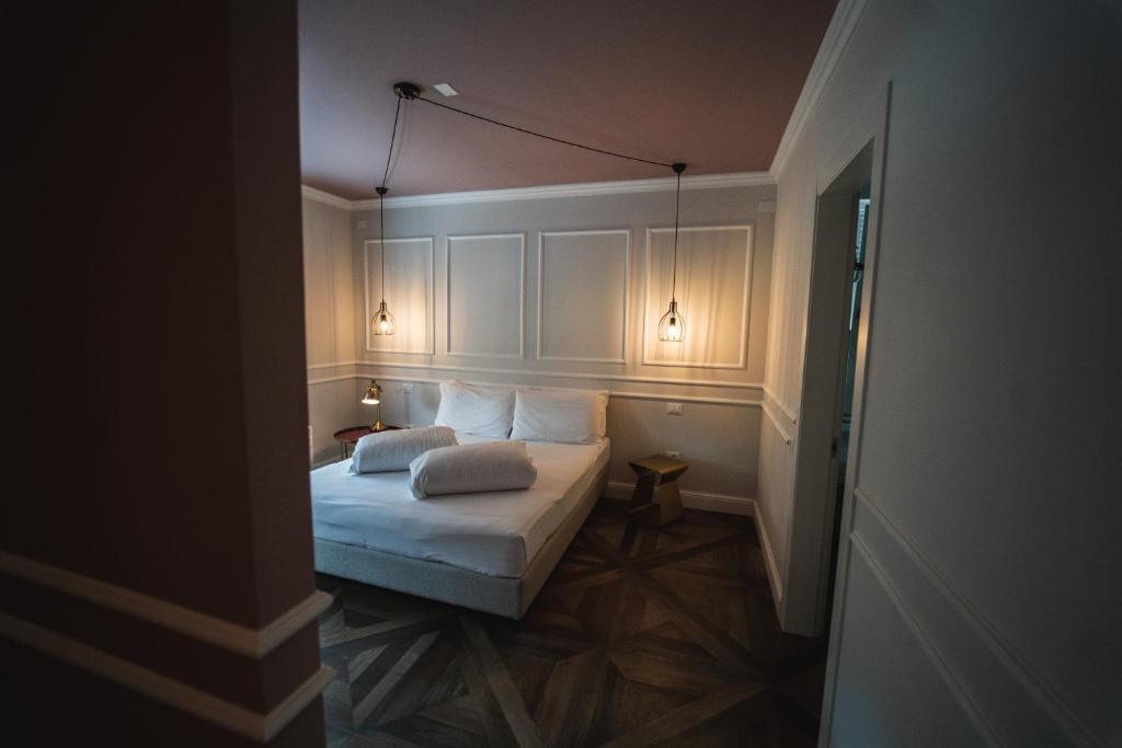 a small bedroom with a bed with two pillows at Locanda Gaudemus Boutique Hotel in Sistiana