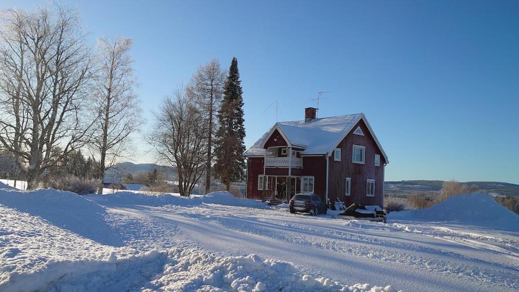 a red house in the snow with a snow covered road at Villa i Näsland in Näsland