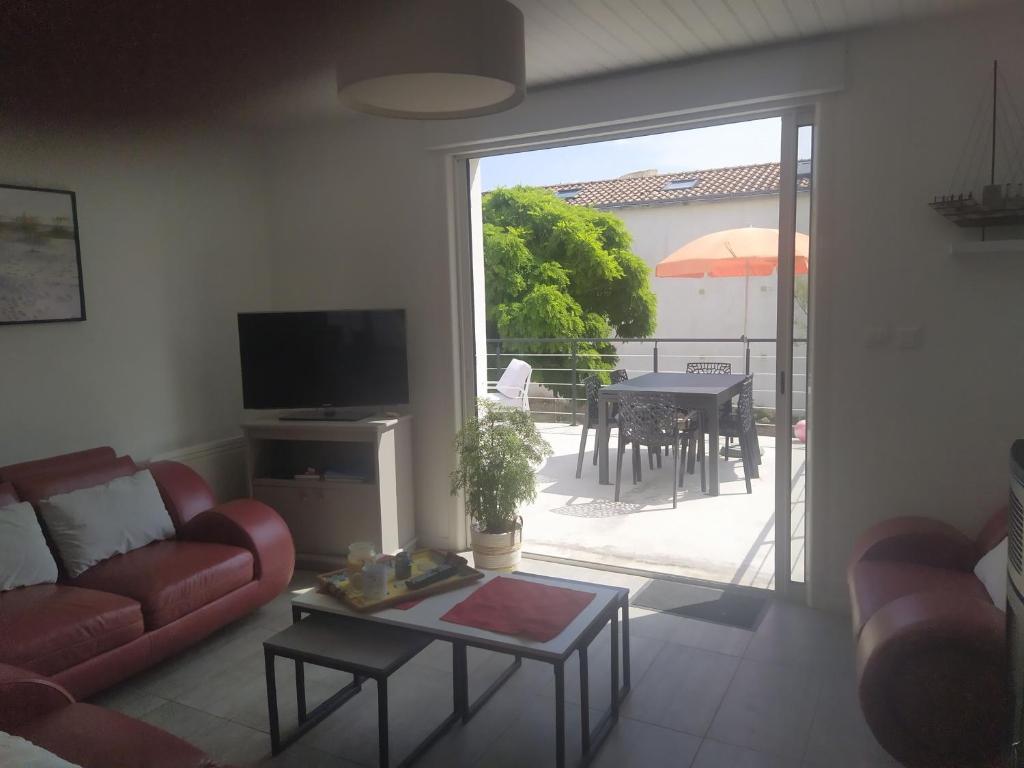 un salon avec un canapé et une table dans l'établissement Maison à 100m de la plage, à Longeville-sur-Mer