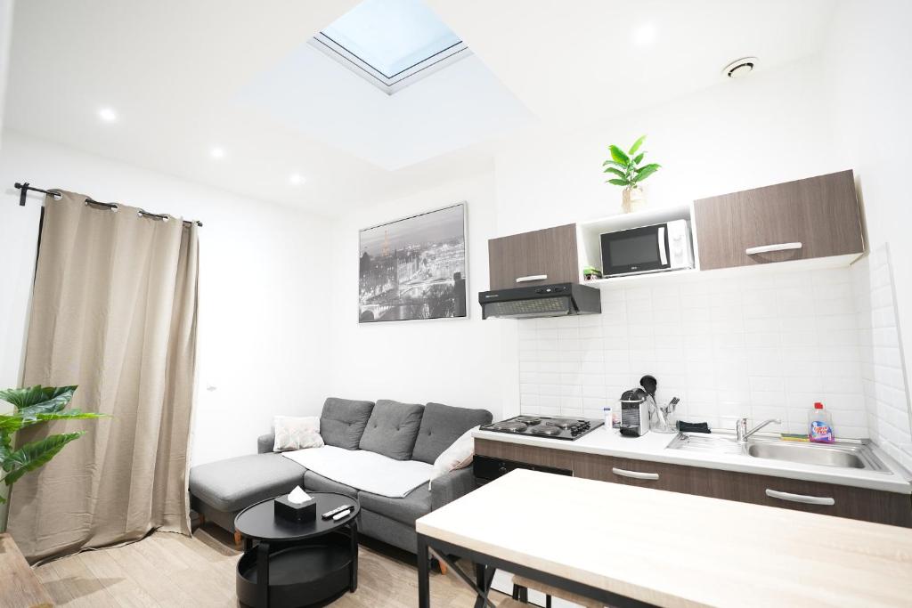 a kitchen and living room with a couch and a table at Beautiful T3, 6 people, Paris-Est, free parking in Bagnolet