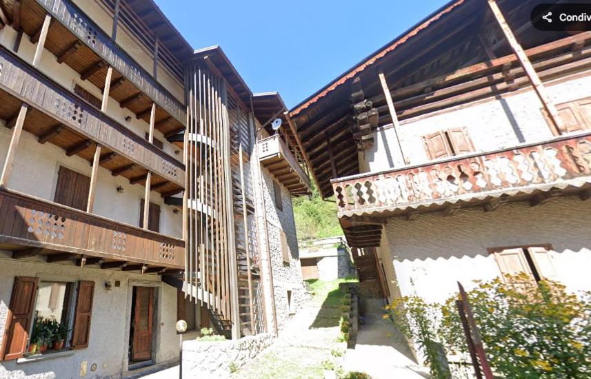 two buildings with wooden balconies next to each other at Oasis House in Forni di Sopra