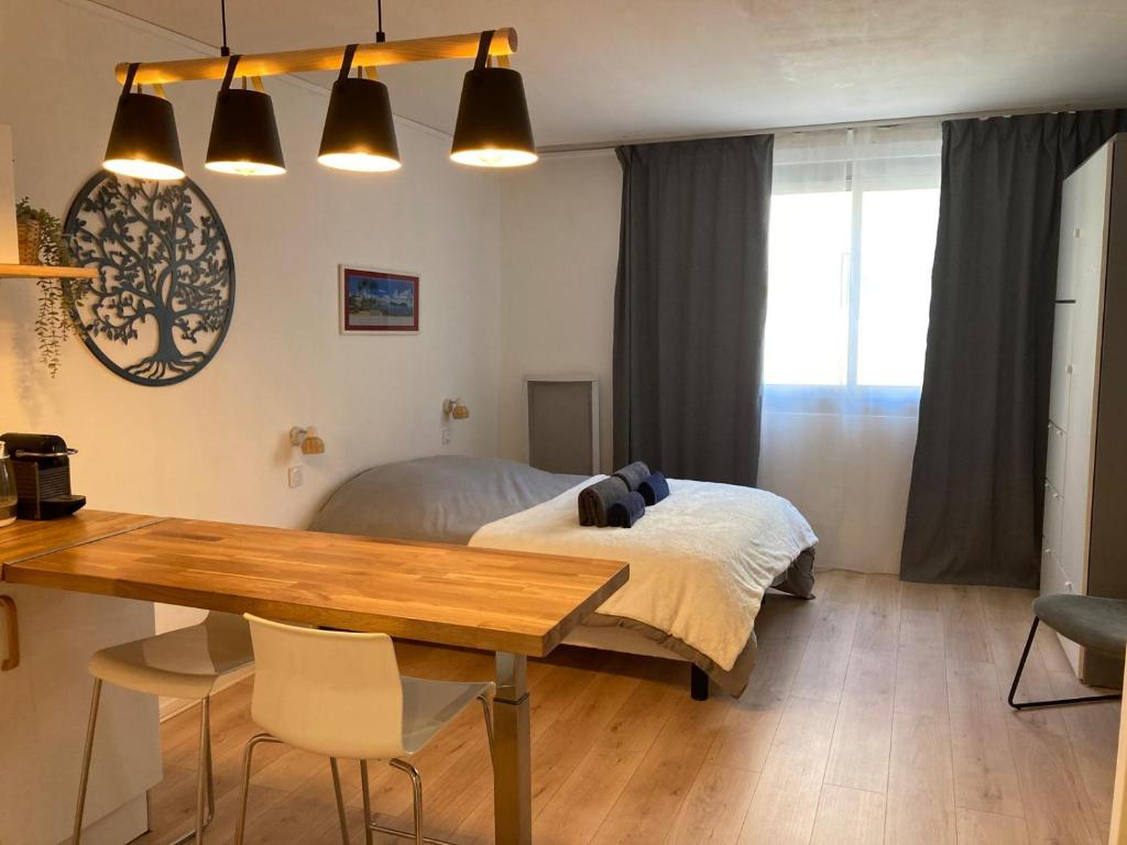 une chambre avec un lit et une table en bois dans l'établissement Appartement cosy et calme en cœur de ville - Quartier Saint Aubin proche gare, à Toulouse