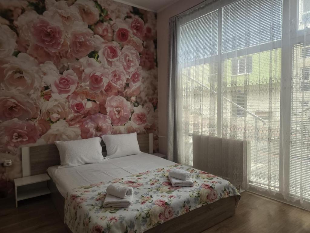 a bedroom with a bed with a floral wall at Roses in Sofia