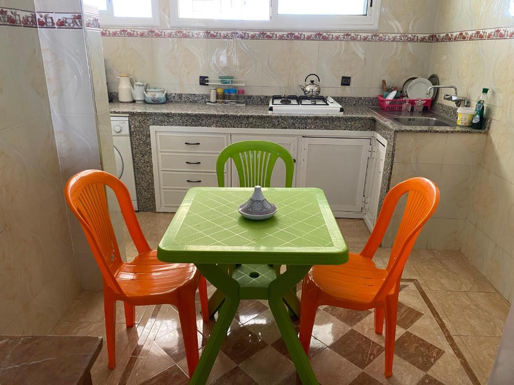 a kitchen with a green table and two chairs at Un appartement haut de gamme in Agadir