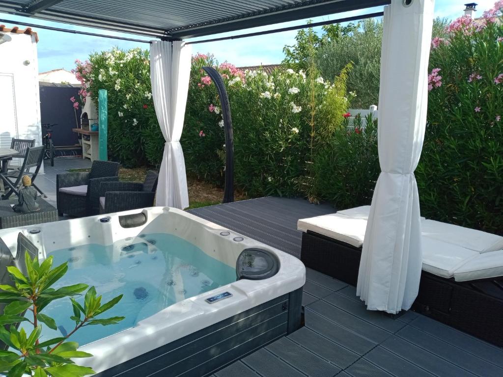 une baignoire jacuzzi assise sur une terrasse dans l'établissement maisonlazenitude-lapalmyre, aux Mathes