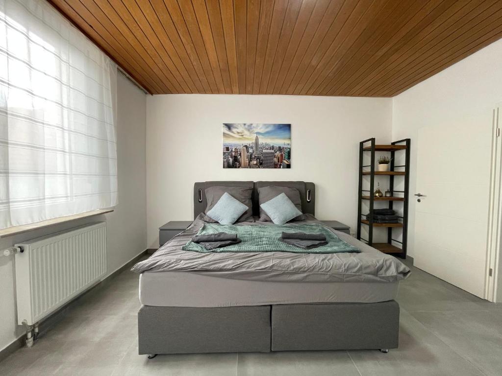 ein Schlafzimmer mit einem Bett und einer Holzdecke in der Unterkunft Danisman Apartments 3 Zentral - Smart - Modern in Saarbrücken