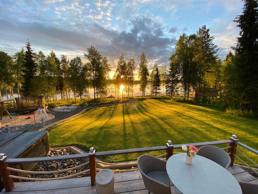 a patio with a table and chairs and a field at Villa beach star in Ranua