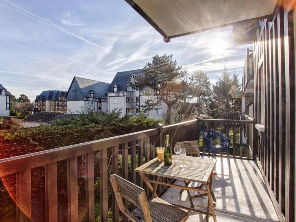 un patio avec une table et des chaises sur un balcon dans l'établissement Appartement à Cabourg avec balcon et parking, proche mer - FR-1-788-41, à Cabourg