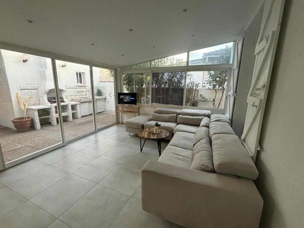 un grand salon avec un canapé et une télévision dans l'établissement Maison de ville Mandelieu la Napoule, à Mandelieu-la-Napoule