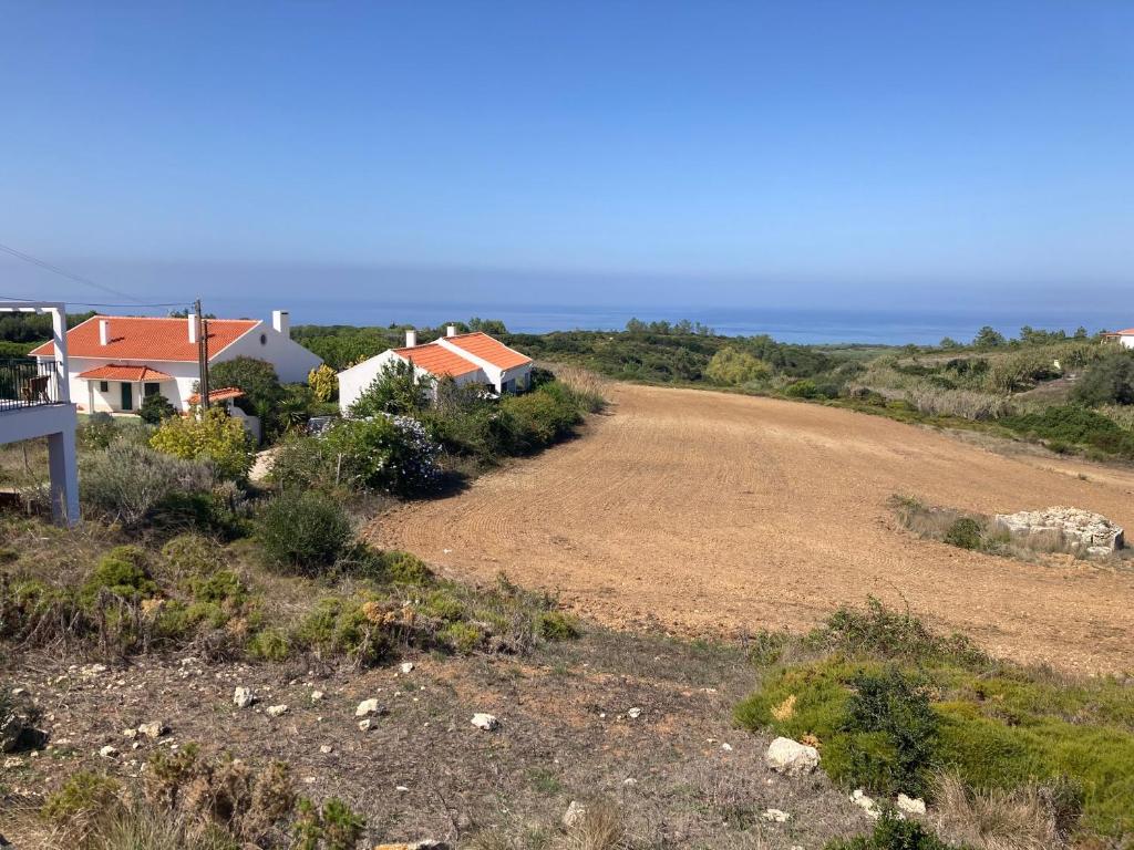 a dirt road next to houses on a hill at Cozy Country House near Beaches in Azoia