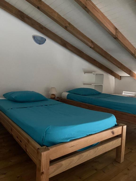 a bedroom with two beds in a attic at Bungalows MALUEVA PREMIUM 1 chambre et 1 mezzanine à 5min de la plage de la Caravelle in Sainte-Anne