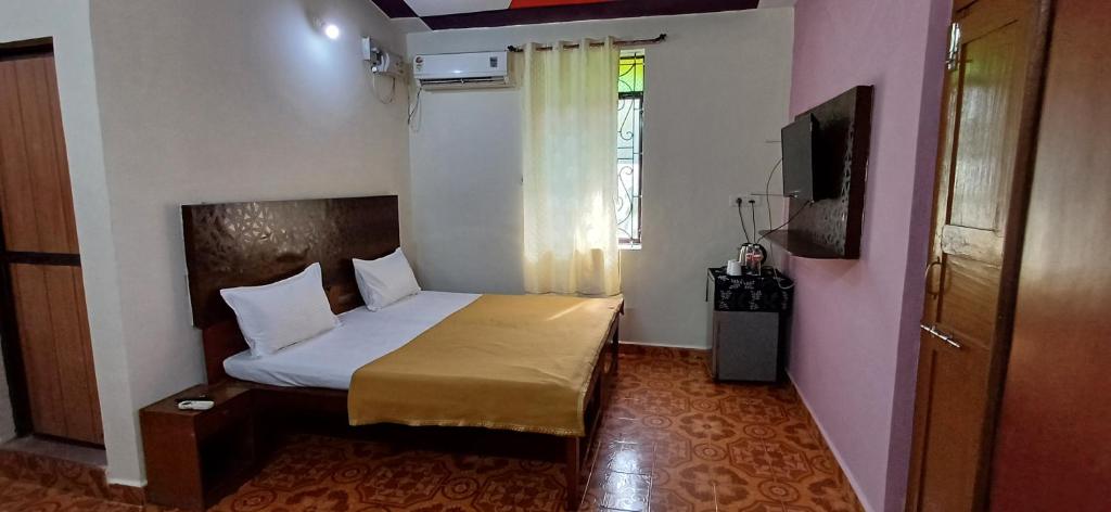 Un dormitorio pequeño con una cama y una ventana. en Kajal guest house, en Calangute