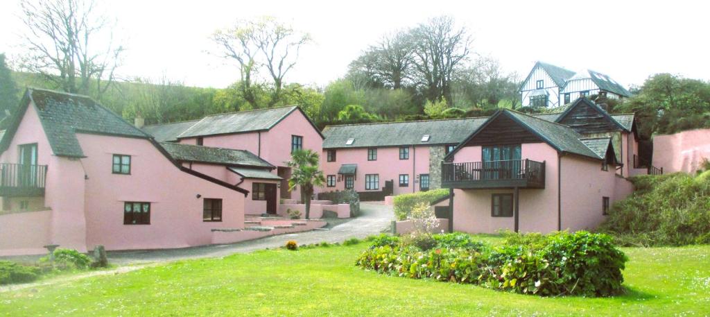 a group of pink houses on a hill at The Dairy in Teignmouth