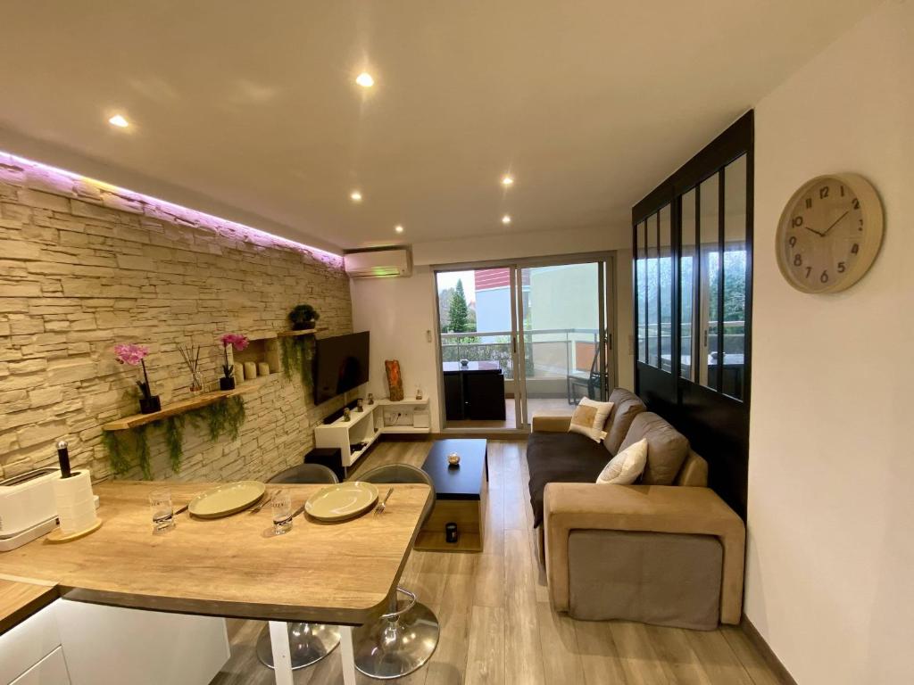 - un salon avec un canapé et une horloge murale dans l'établissement F1 Saint Laurent du Var Proximity to beach-Clim Wifi, à Saint-Laurent-du-Var