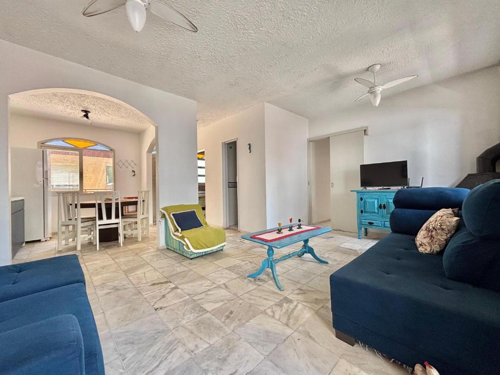 a living room with a blue couch and a table at Apartamento a beira-mar in Capão da Canoa