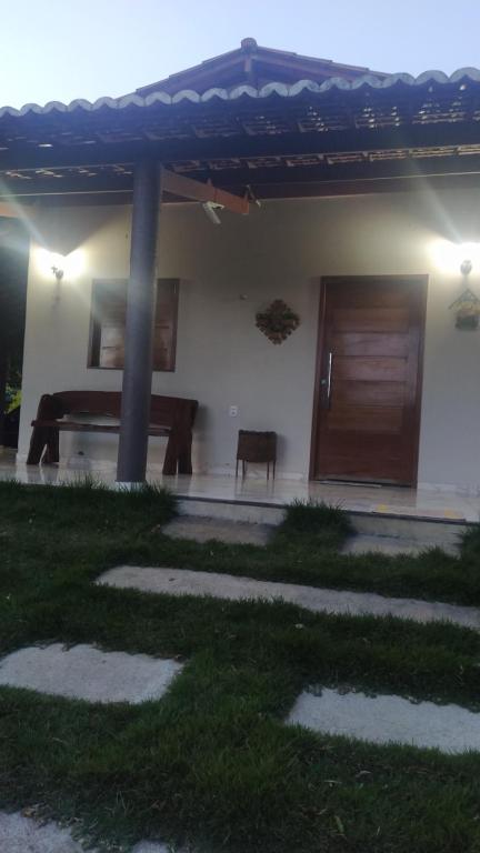 a house with a table and a wooden door at Casa de Campo na Serra in Ibiapina