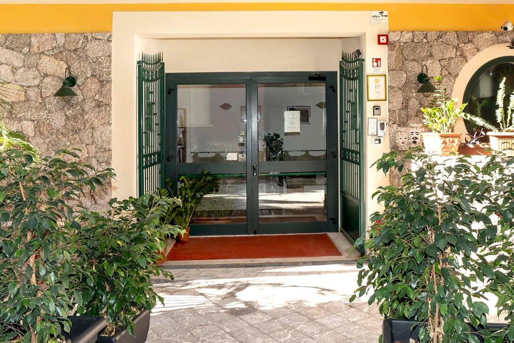 an entrance to a building with a green door at Le Tartarughe Aparthotel in Letojanni