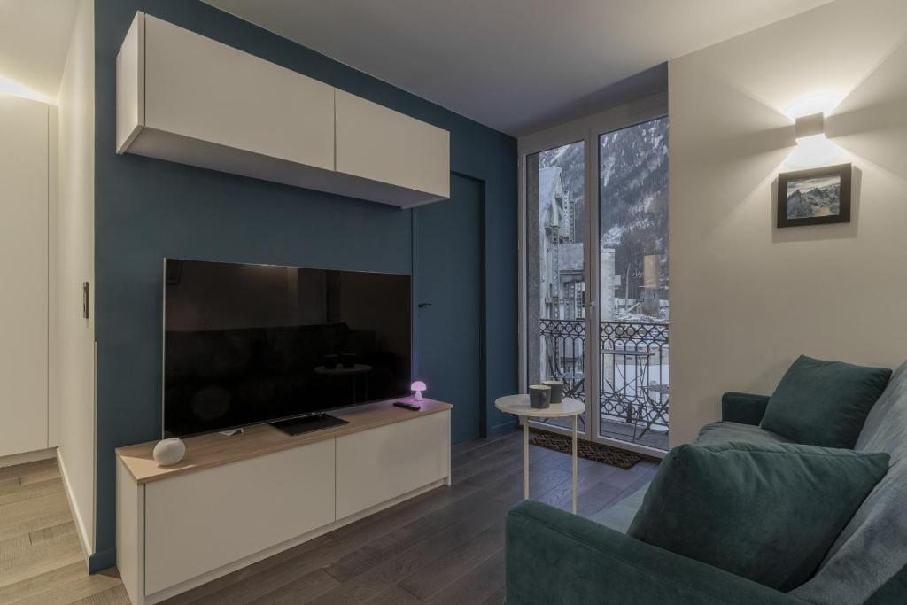 - un salon avec une grande télévision et un canapé dans l'établissement Le Lyret - Au Centre avec Vue Spectaculaire, à Chamonix-Mont-Blanc