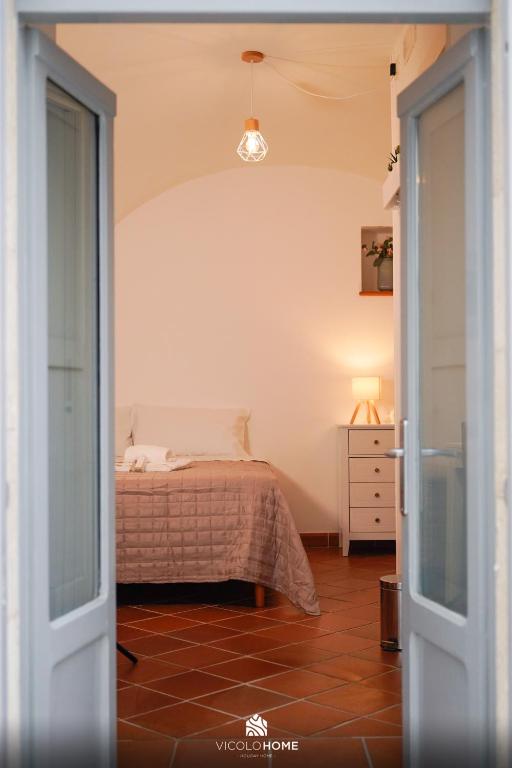 a bedroom with a bed and a door leading into a room at Vicolo Home in Putignano