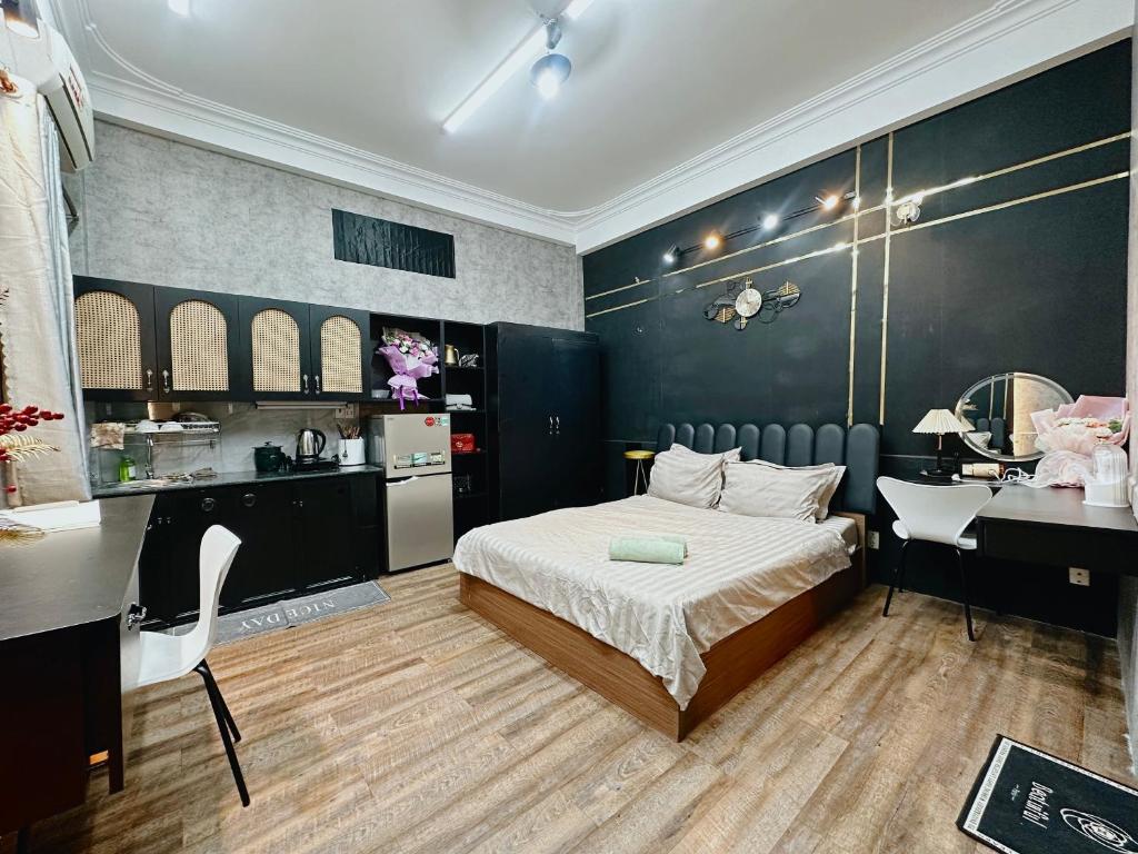 a bedroom with a bed and a desk and a kitchen at 17C đặng văn ngữ 102 in Ho Chi Minh City