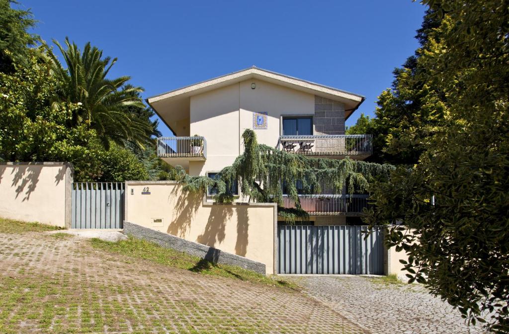 una casa bianca con una recinzione e alberi di Charming Villa Viana do Castelo a Viana do Castelo