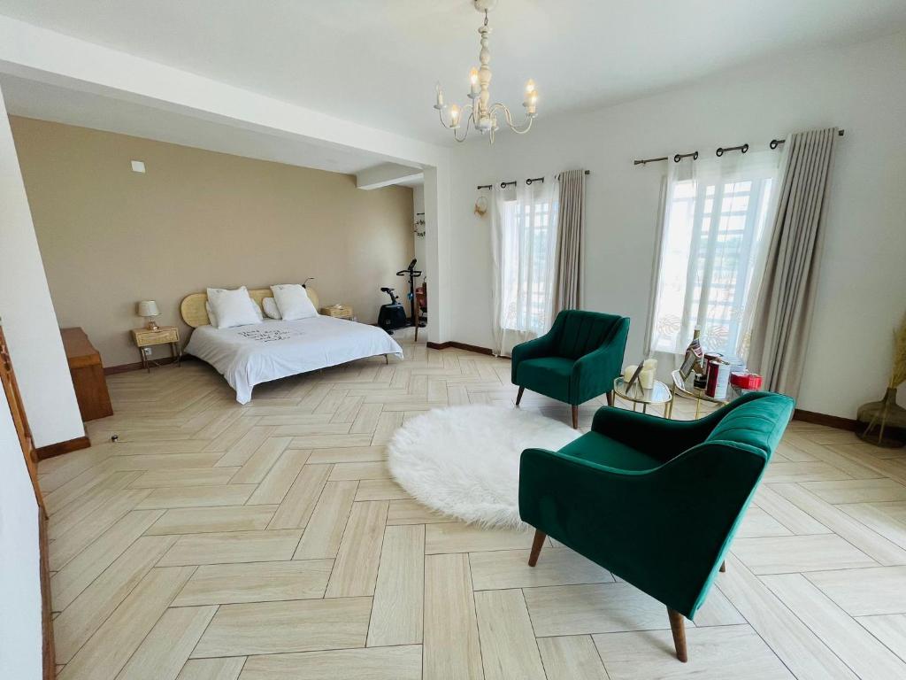 ein Schlafzimmer mit einem Bett, einer Couch und einem Sessel in der Unterkunft Tia Vahine in Ivato