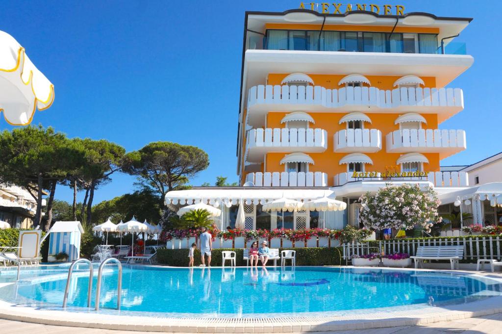 a hotel with a swimming pool in front of a building at Hotel Alexander in Caorle