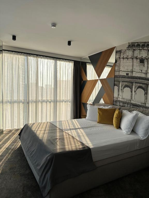 a bedroom with a large bed with a large window at MM Boutique Hotel in Burgas