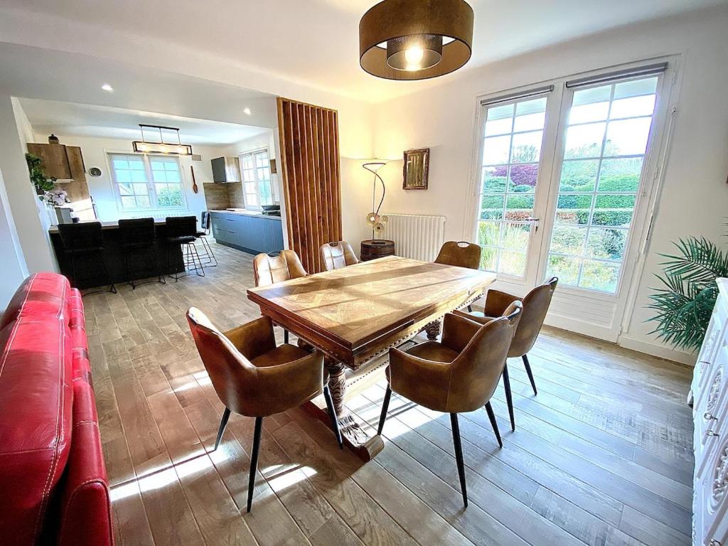 un salon avec une table et des chaises en bois dans l'établissement Maison Renovée Plomelin - Countryside and Beaches, à Plomelin