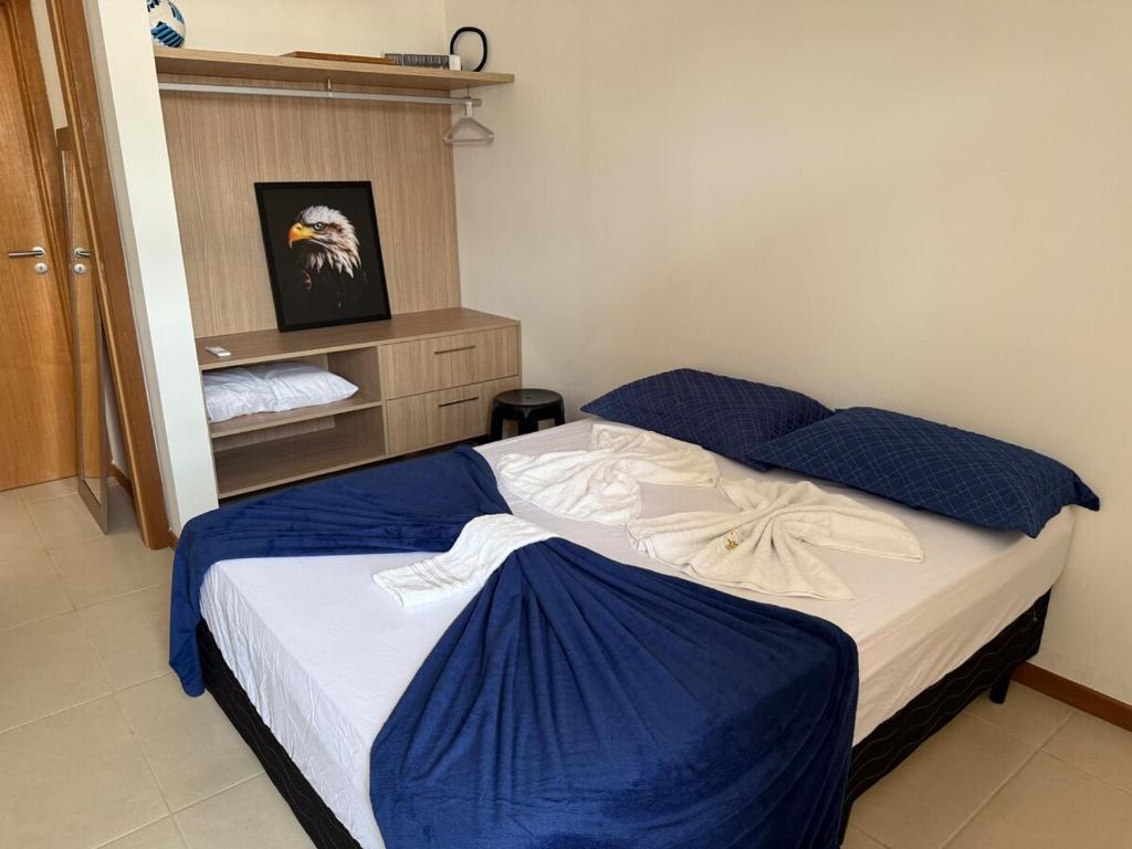 une chambre avec un lit avec des draps bleus et blancs dans l'établissement Excelente em Itacimirim novo, à Camassari