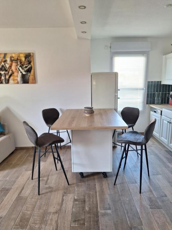 une cuisine avec une table en bois et quatre chaises dans l'établissement Parc de la roseraie, à Marseille
